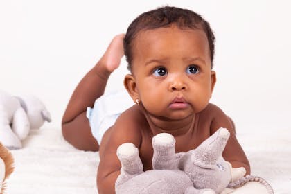 Baby doing tummy time with soft toy