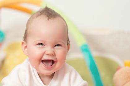 laughing baby with play gym