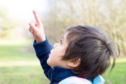 child with finger in air