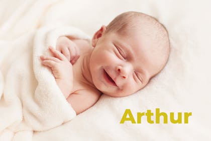 Baby smiling wrapped in towel. Name Arthur written in text