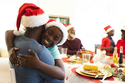 Father hugging son at Christmas table