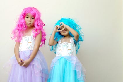 Two girls dresses in pink and blue wigs and fancy chiffon dresses