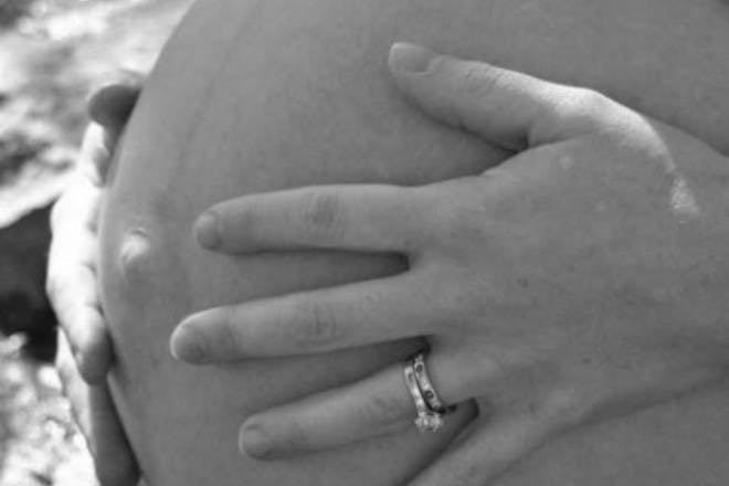 hands holding pregnant belly