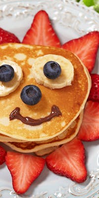 Pancakes with a sun face made from fruit