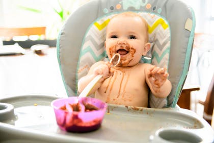 Baby eating chocolate with a spoon