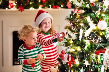 Children hanging decorations on the Christmas tree