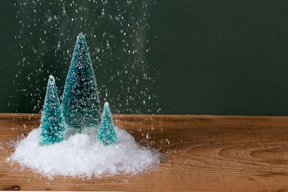 Fake snow falling on a mini Christmas tree