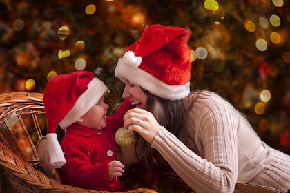 Mum and baby wearing Santa hats