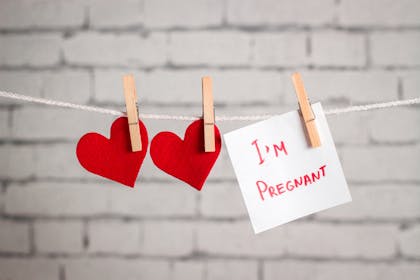 Two hearts and a post-it saying 'I'm pregnant' pegged to a clothes line