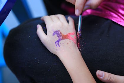 Child with a glittery unicorn tattoo