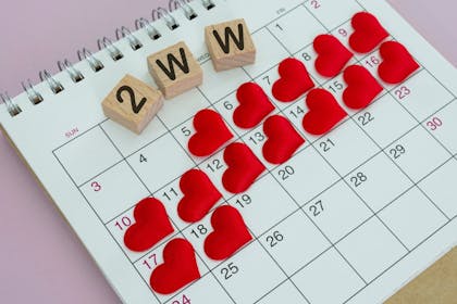 A calendar with fourteen days covered by heart stickers, and wooden blocks with 2WW on them