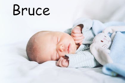 A baby sleeping with the name Bruce written in text