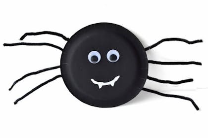 Spider craft made from a black paper plate, pipe cleaners and googly eyes