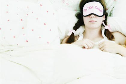 woman with eye mask sleeping in bed