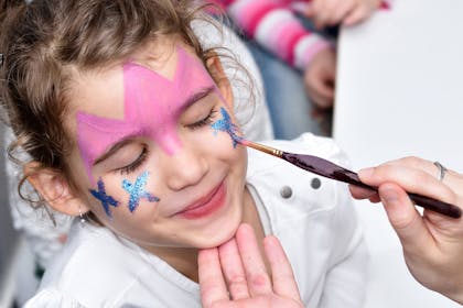 A little girl having her face painted