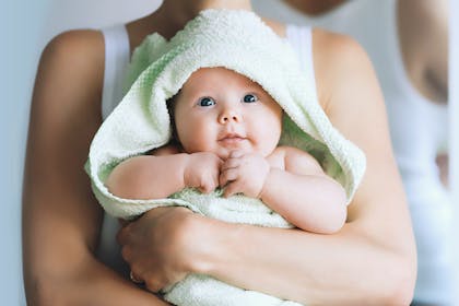 Baby after bath time in green towel