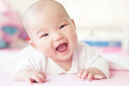 Little girl laughing and lying down on her tummy 