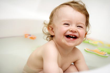 Baby with teeth grinning in bath