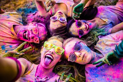Teenage girls covered in coloured paint after a colour fight