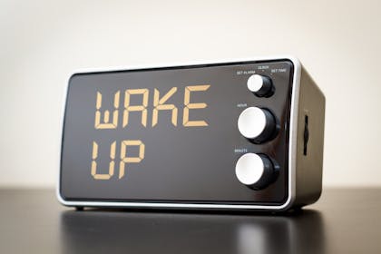 Alarm clock with digital display reading 'wake up'