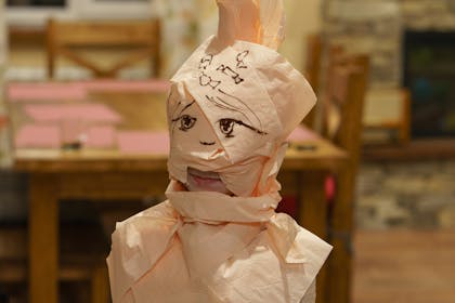 A toddler dressed as a mummy wrapped in toilet roll bandages for Halloween