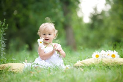 baby girl in field with flowers