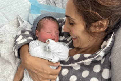 Dr Sara Kayat holds her newborn baby and smiles