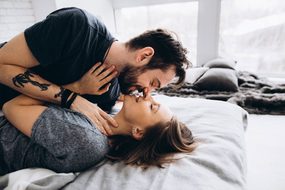 муж и жена целуются в губы в кровати