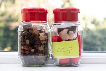 Christmas Elf on the Shelf gets stuck in a jar with a sign saying 