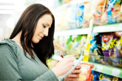 woman ticking off items on list in shop