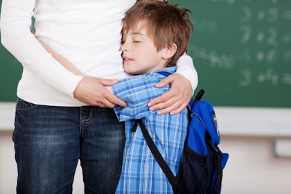 School boy hugging his mother
