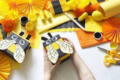 Child holding bees made from craft materials