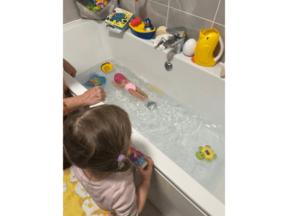 Girl playing with baby toy in bath