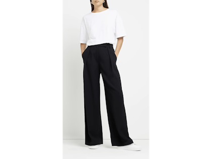 Woman wearing black trousers with a white t shirt