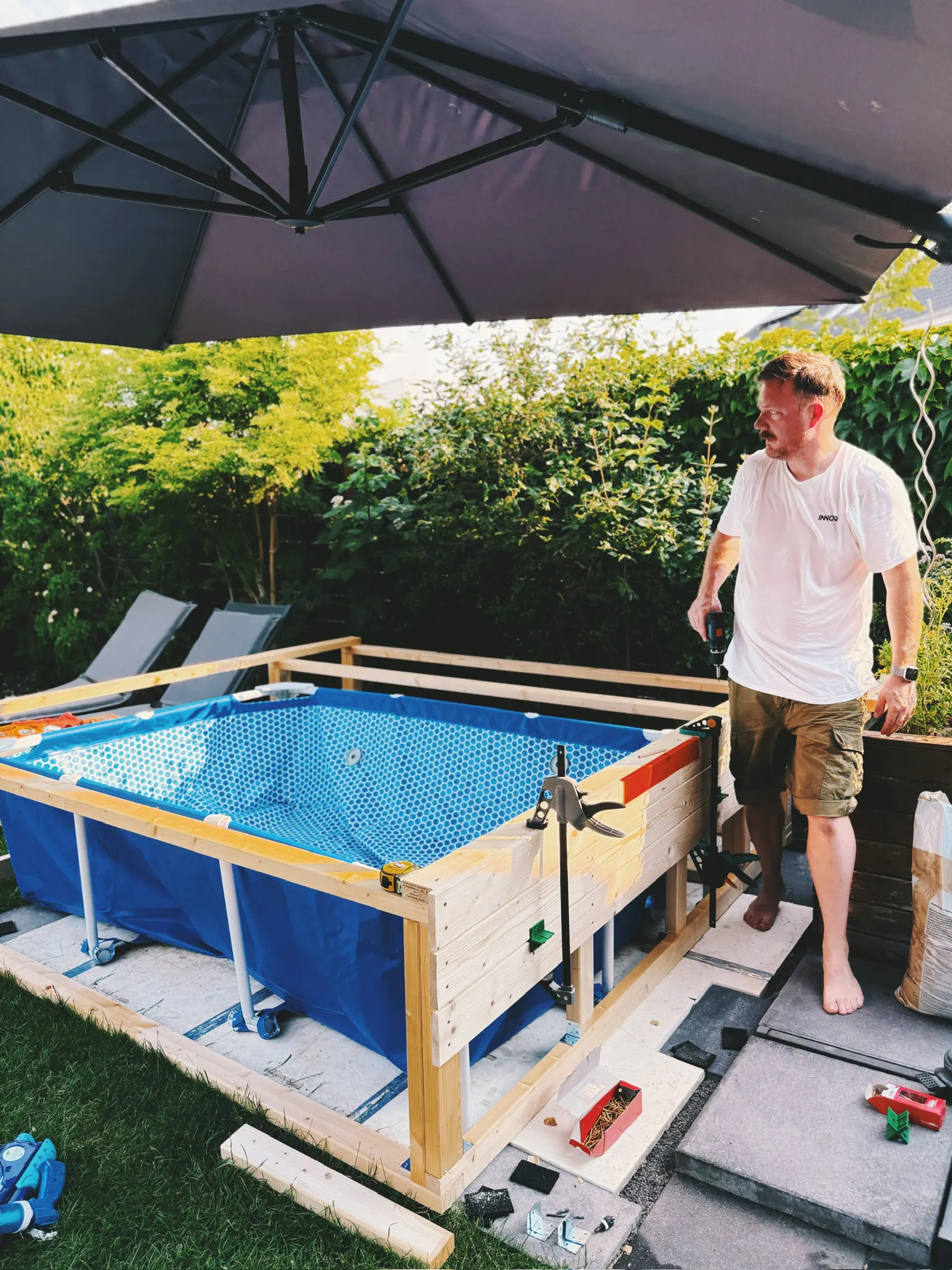 Roman steht neben der Poolbaustelle