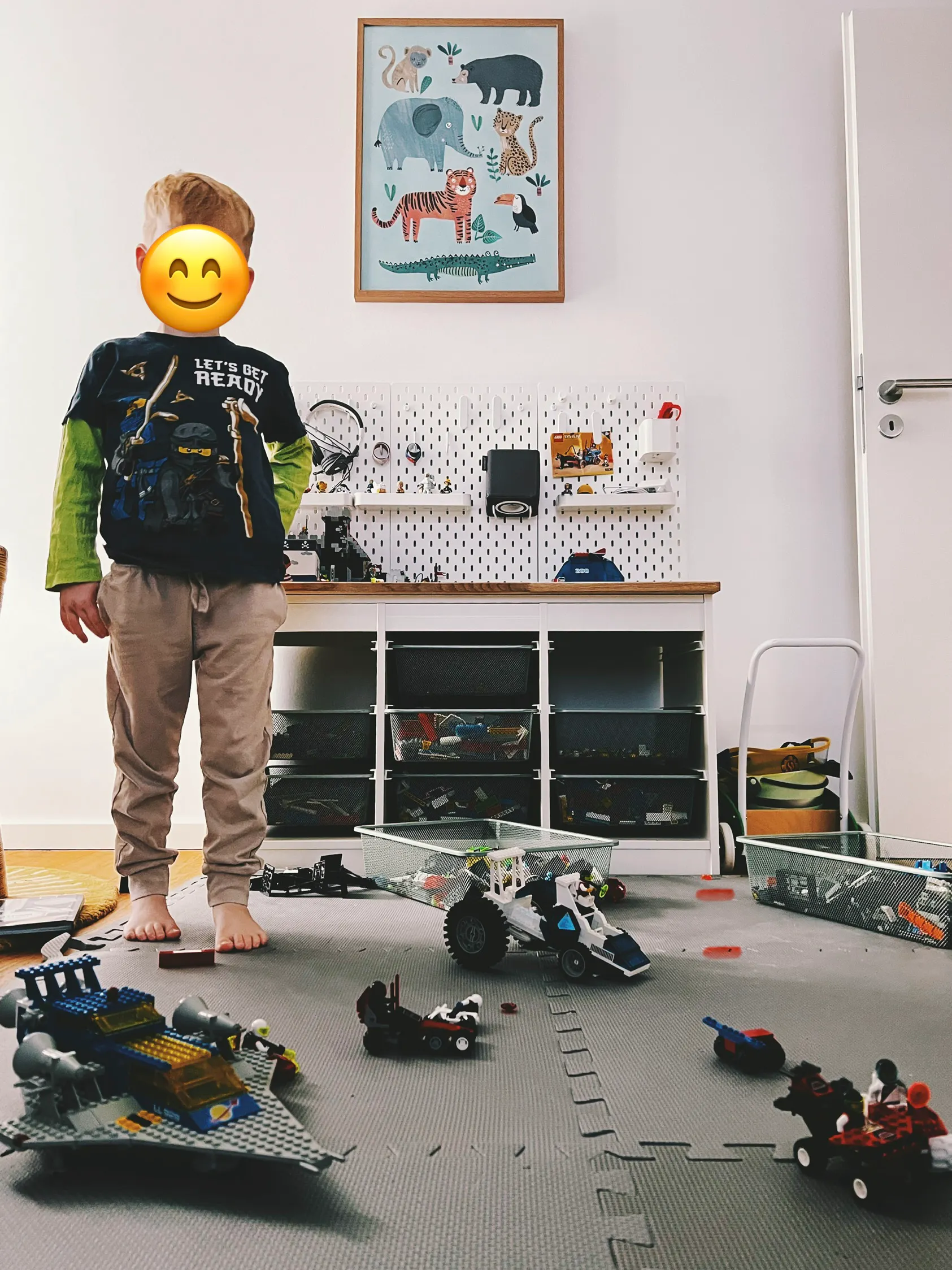 Max, der in seinem Zimmer zwischen Lego Bauten steht