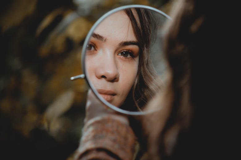 Une femme admirant son reflet devant un miroir