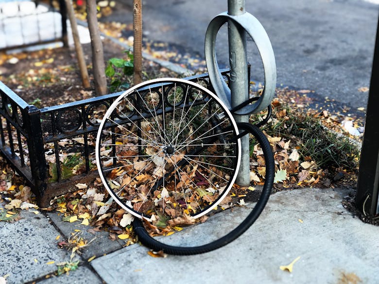 La roue d'un vélo volé, encore attachée à un poteau