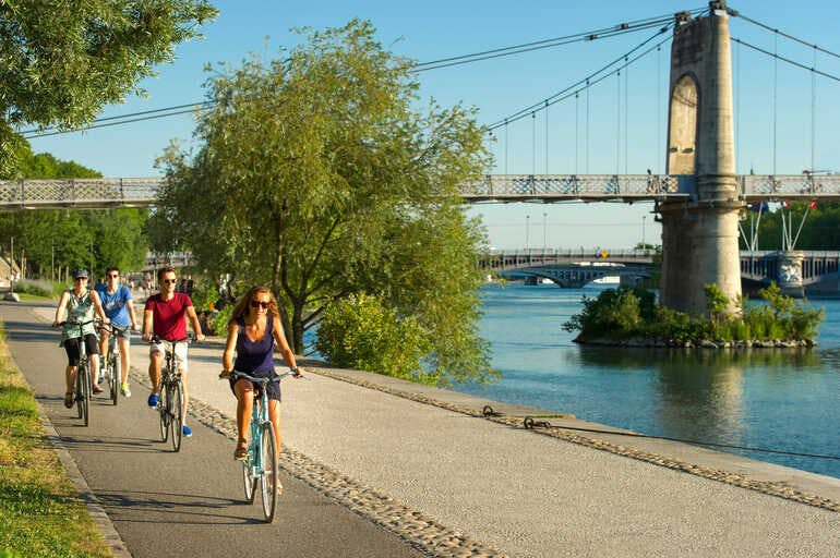 Un groupe de cyclistes sur les berges de Lyon où passe la Via Rhôna