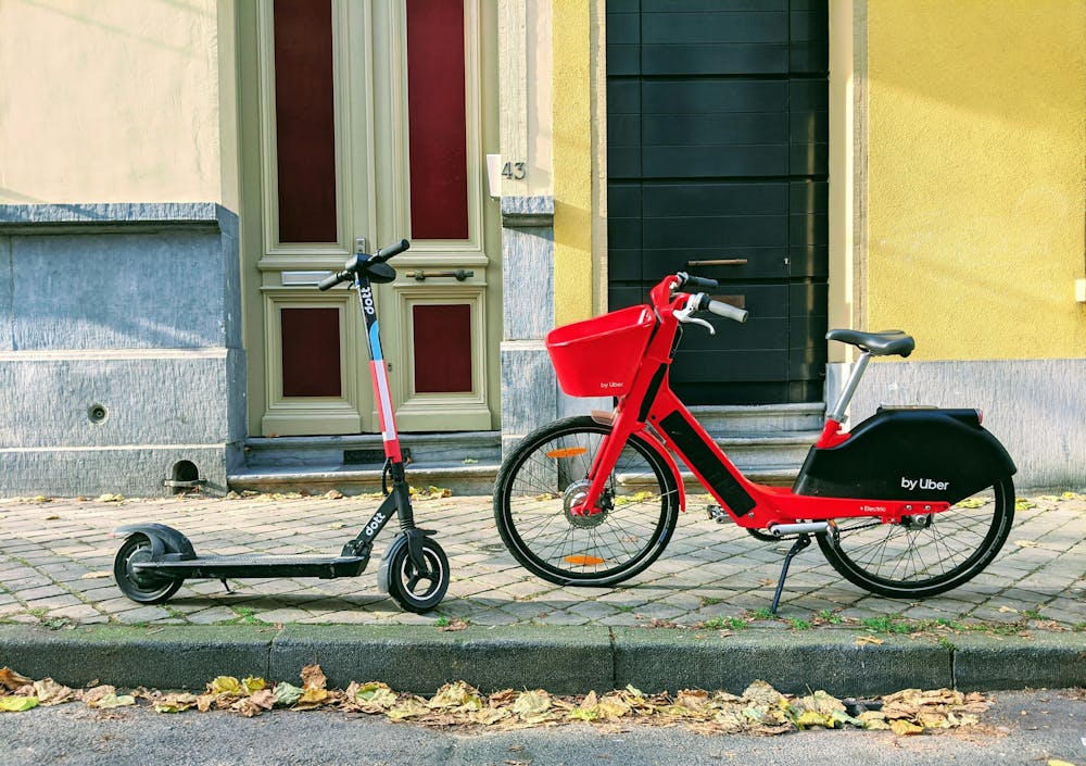 Une trottinette électrique et un vélo électrique sur un trottoir