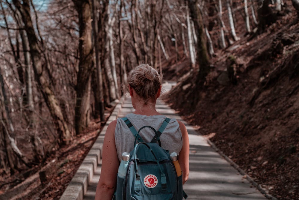 Une femme avec un sac à dos qui se promène en forêt