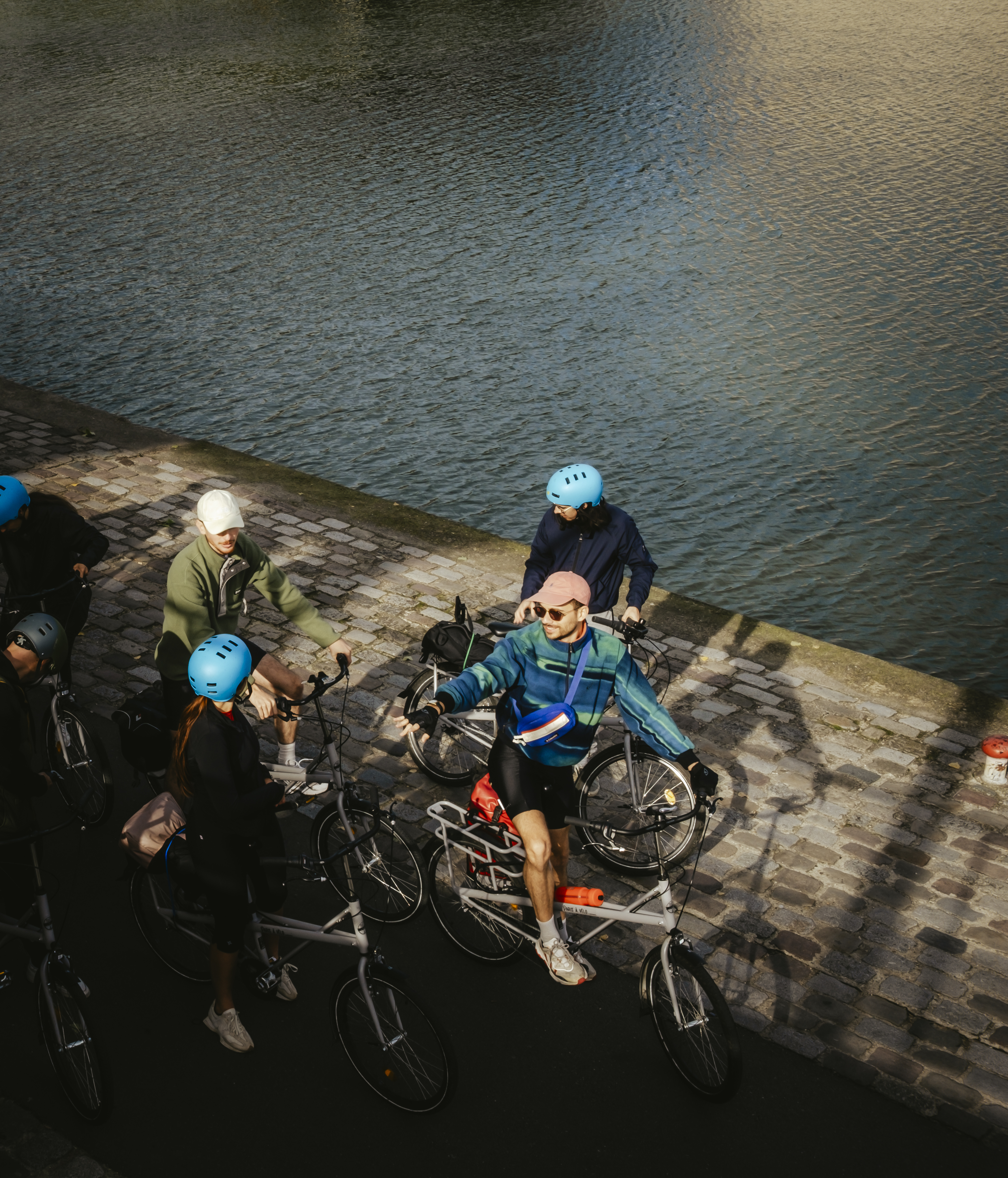 Un groupe de cyclistes au bord de l'eau qui ont loué des vélos pour leurs vacances