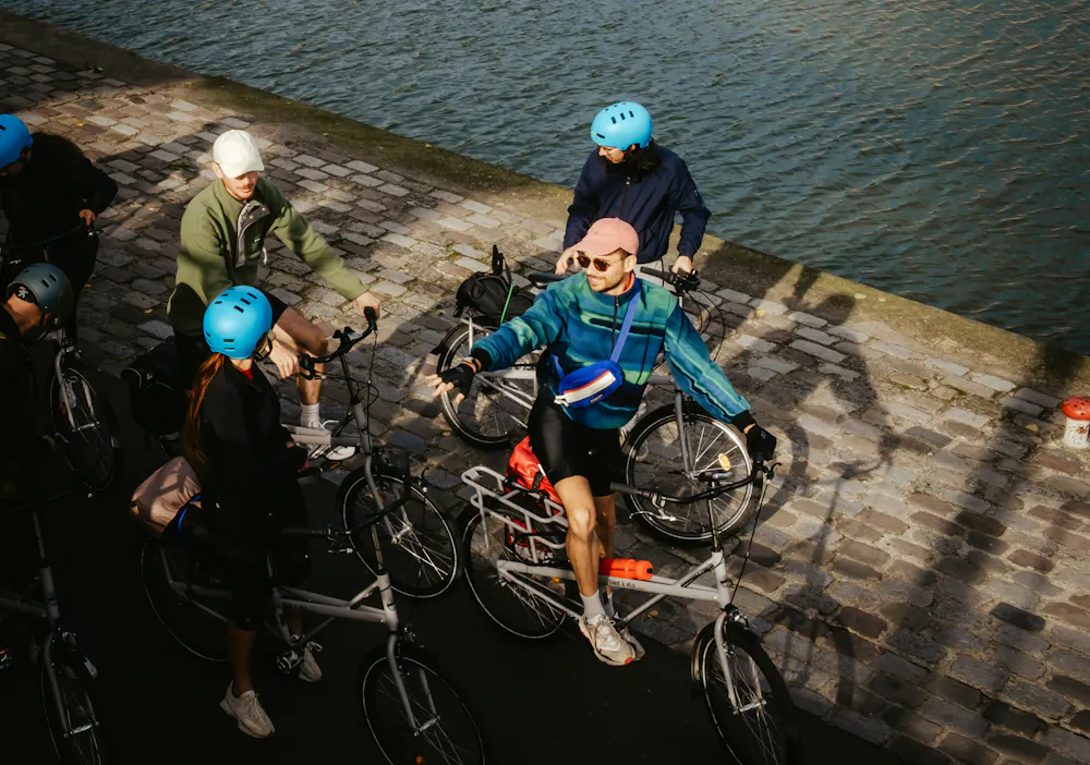 Un groupe de cyclistes au bord de l'eau qui ont loué des vélos pour leurs vacances