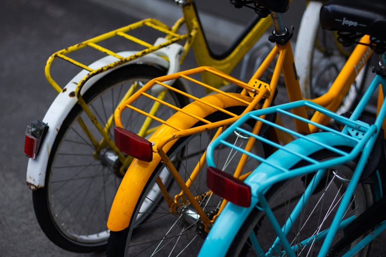 Trois porte-bagages de vélos jaune, blanc et bleu