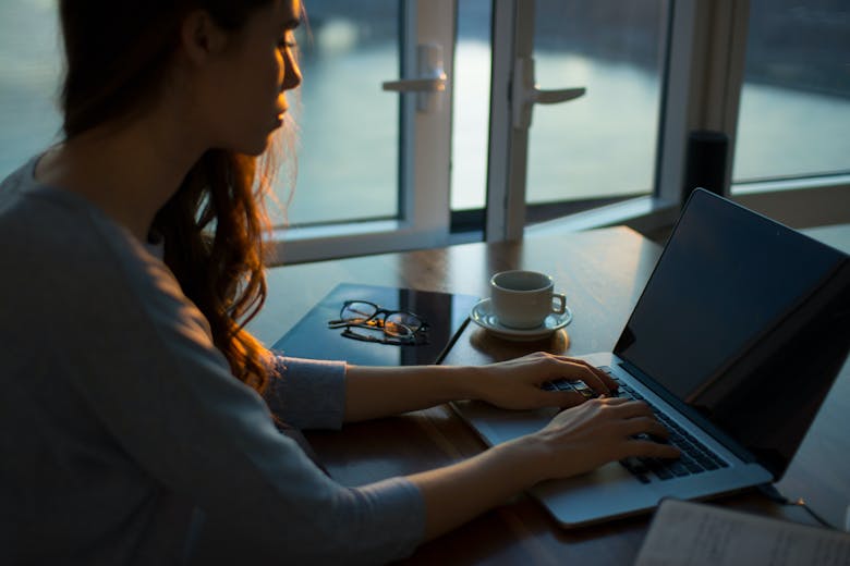 Une femme concentrée qui travaille sur son ordinateur portable