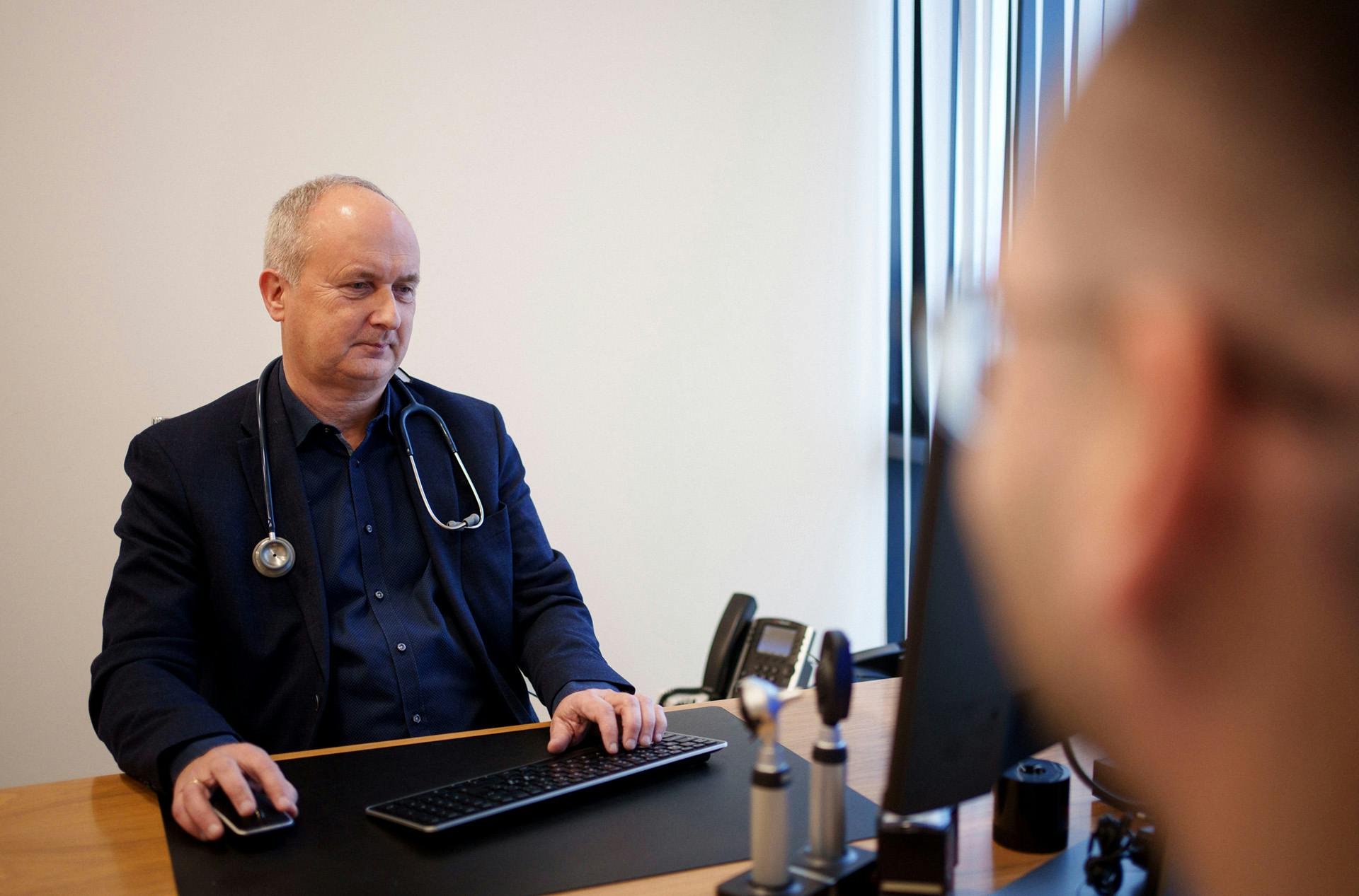 Heilsugæslulæknir situr við tölvu