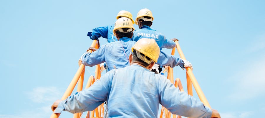 men with construction hats on a ladder