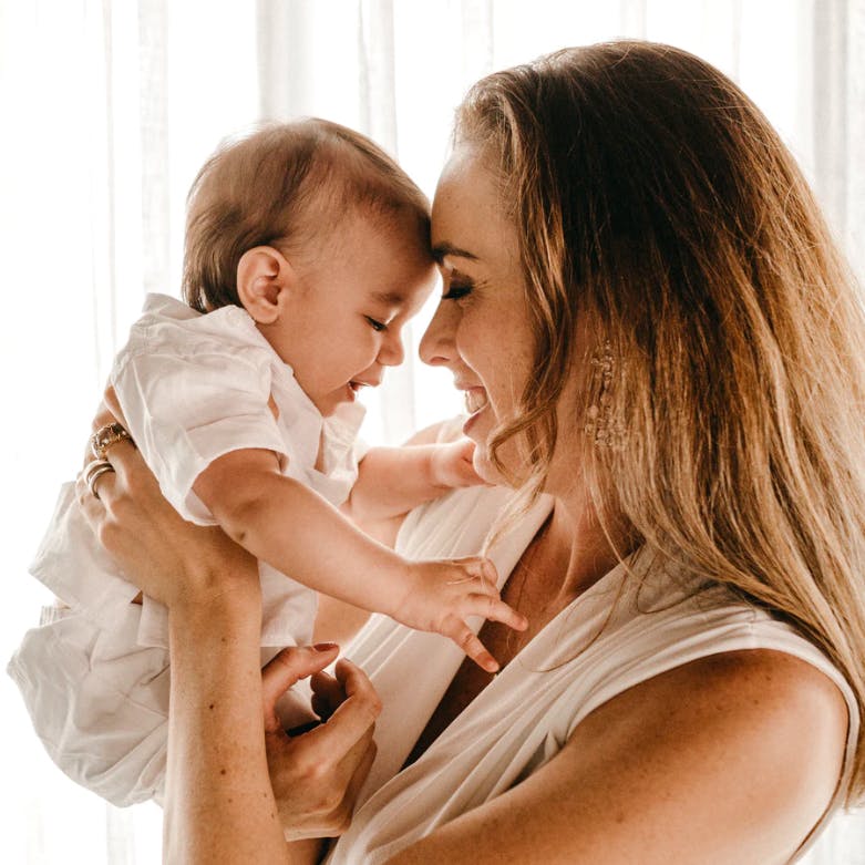 Mother and baby laughing in new home