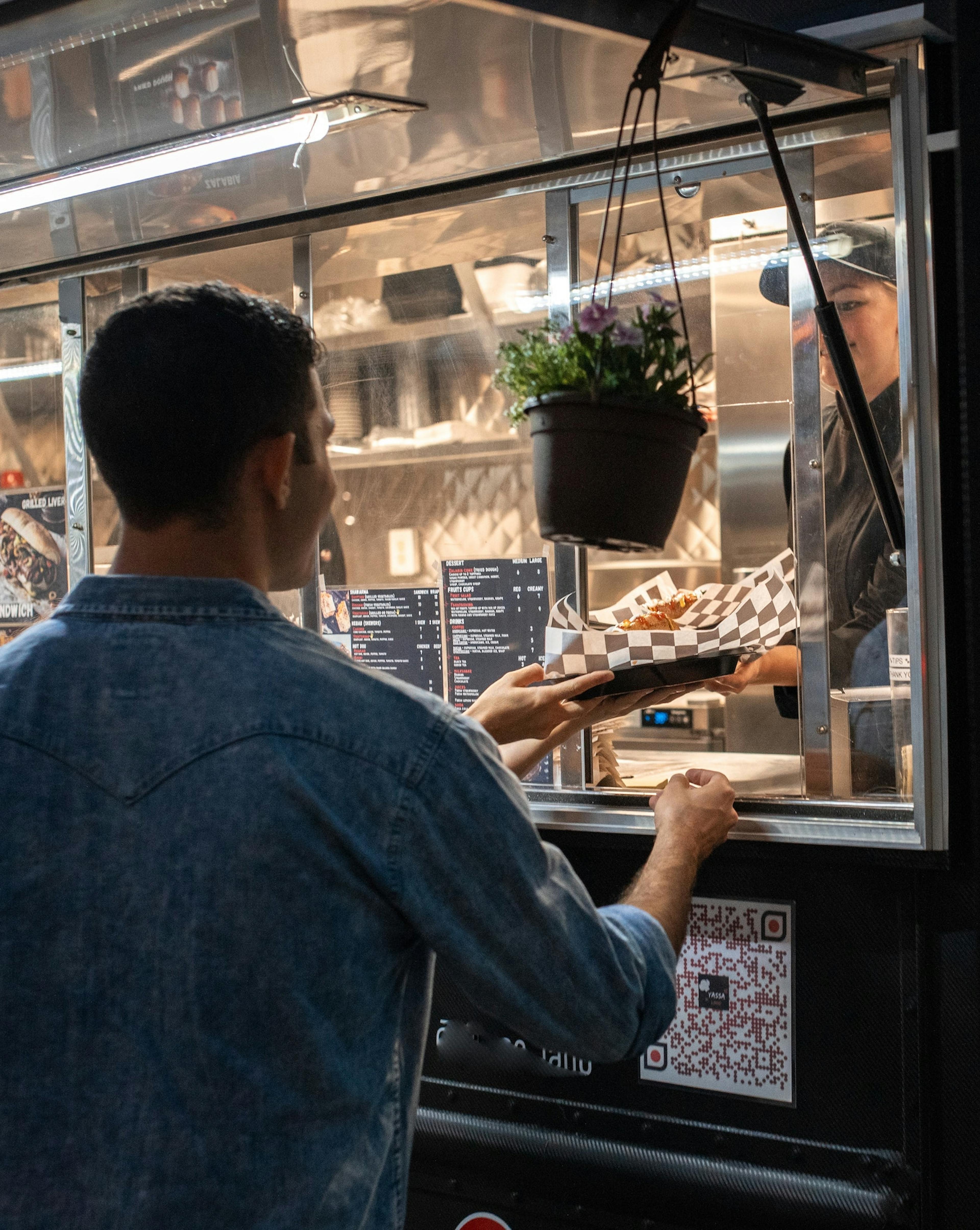 Man being served from a Mexican food truck. 