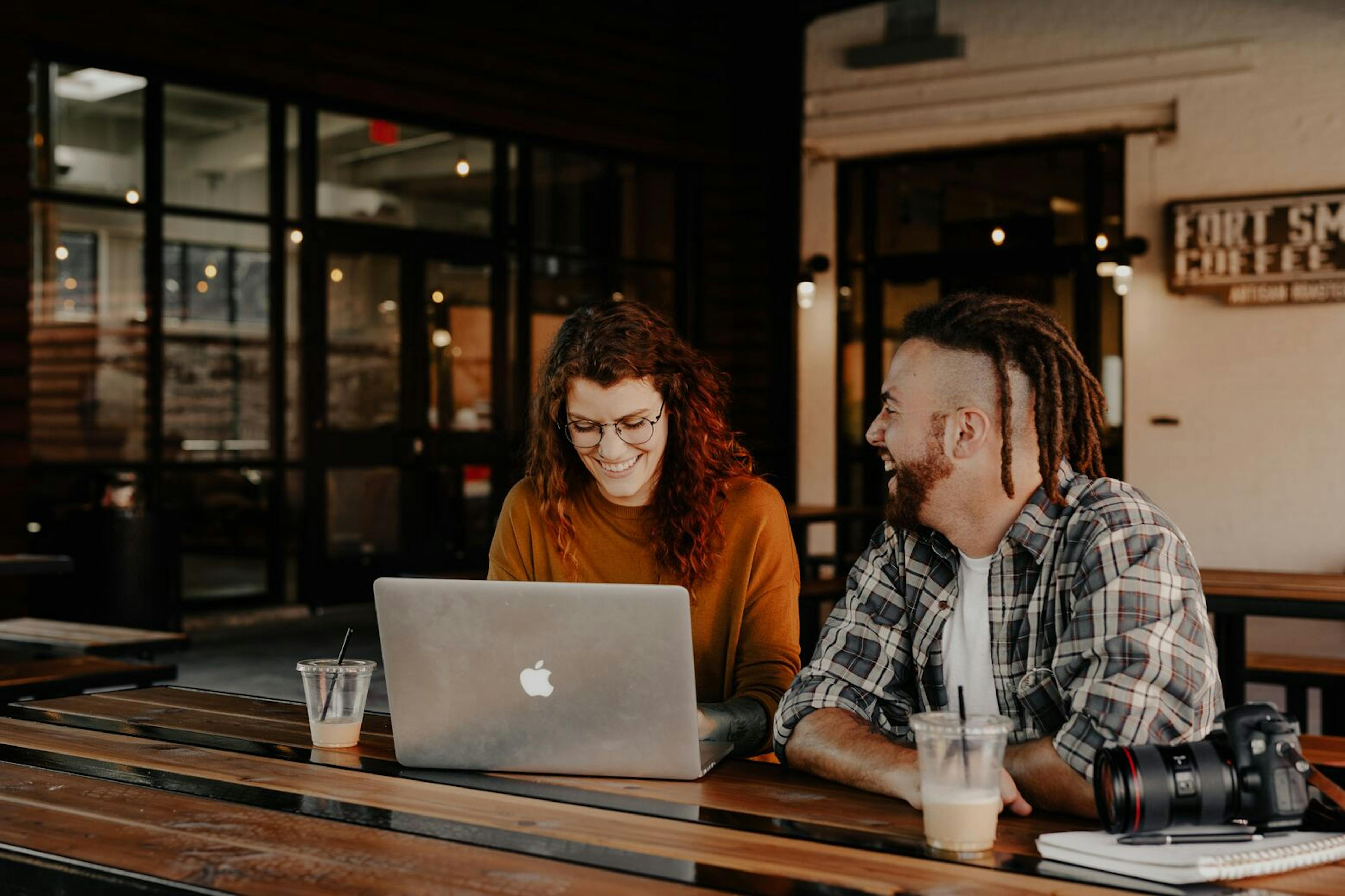 Image of a man and woman laughing at a cafe